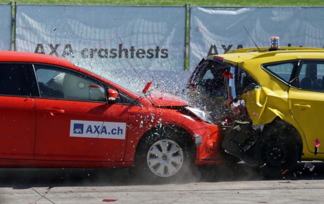 Red car crashing into yellow car during crash test, illustrating the dangers of driving under the influence.