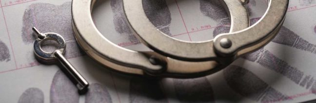 Handcuffs and a key on fingerprint background, symbolizing legal matters related to criminal justice and DUI offenses in Virginia.
