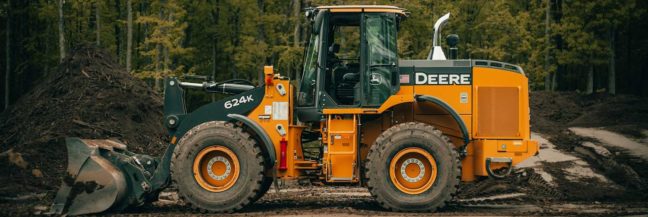 Construction equipment, specifically a John Deere 624K loader, on a job site with dirt piles, relevant to construction law and property damage discussions.