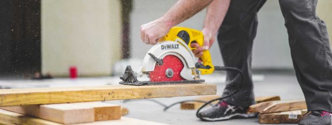 Person using a Dewalt circular saw to cut wood, illustrating contractor work relevant to legal disputes over oral contracts.