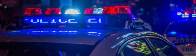 Police car with illuminated lights, emphasizing law enforcement presence related to DUI and DWI discussions.