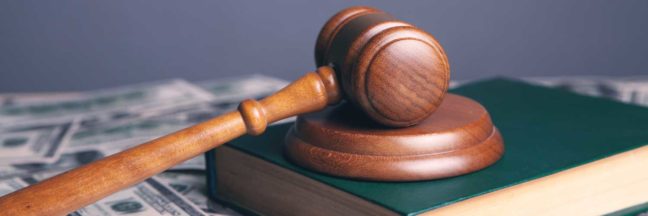 Gavel resting on a law book with scattered dollar bills, symbolizing legal costs and custody issues in divorce proceedings.
