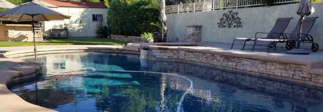 Swimming pool with clean water, lounge chairs, and an umbrella, representing pool maintenance and potential legal issues related to pool companies.
