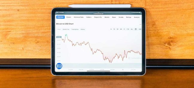 Tablet displaying Bitcoin to USD price chart, illustrating financial trends relevant to divorce asset division discussions.