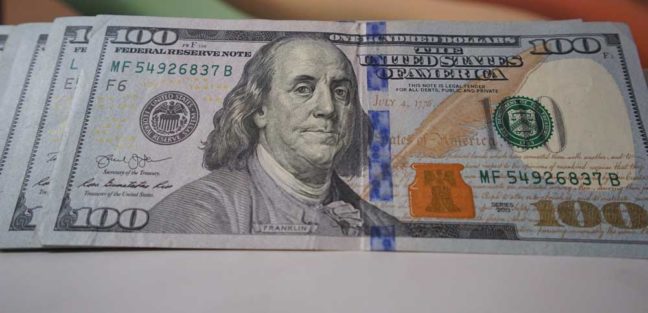 One hundred dollar bill featuring Benjamin Franklin, symbolizing financial considerations in divorce proceedings.