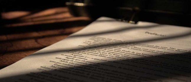 Document with text partially illuminated by shadows, symbolizing legal processes and mediation discussions in family law contexts.