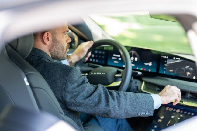 Man driving a modern car, focusing on the dashboard display, relevant to discussions on reckless driving and legal representation in Virginia.